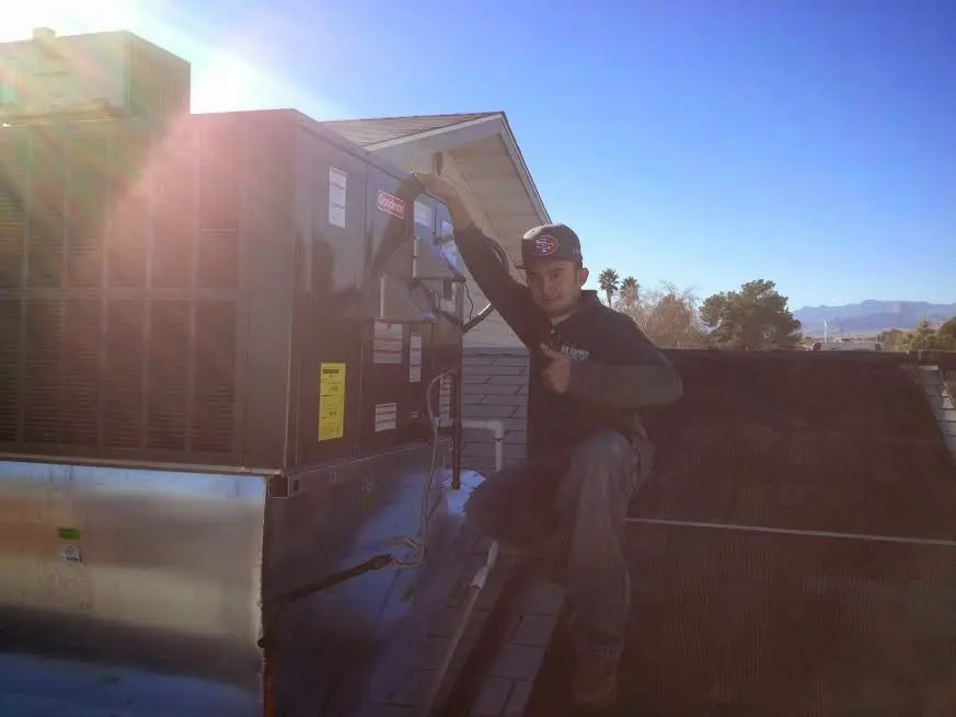 HVAC technician performing HVAC Inspection on a rooftop unit in South Kingstown